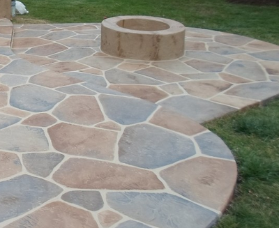 Decorative stone stamped concrete patio with a built in fire pit in Danbury.