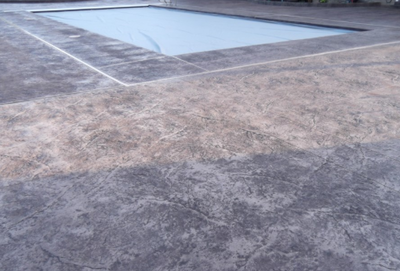 Stamped gray concrete textured around built in pool.