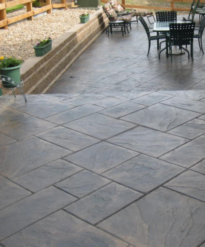 Brown and gray tile-style stamped concrete walkway and patio.